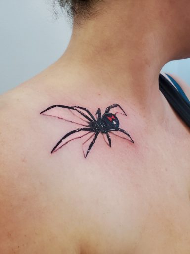 A realism style black widow spider tattoo. 
