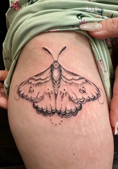 Fine line tattoo of a detailed moth on a person's thigh.